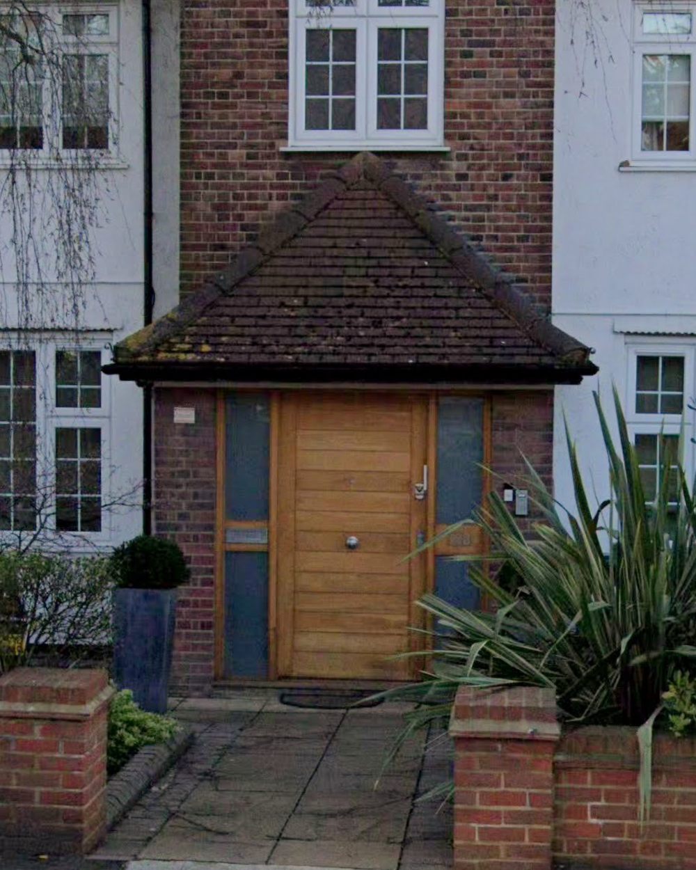 Close-up of the solid oak front door and tiled porch canopy