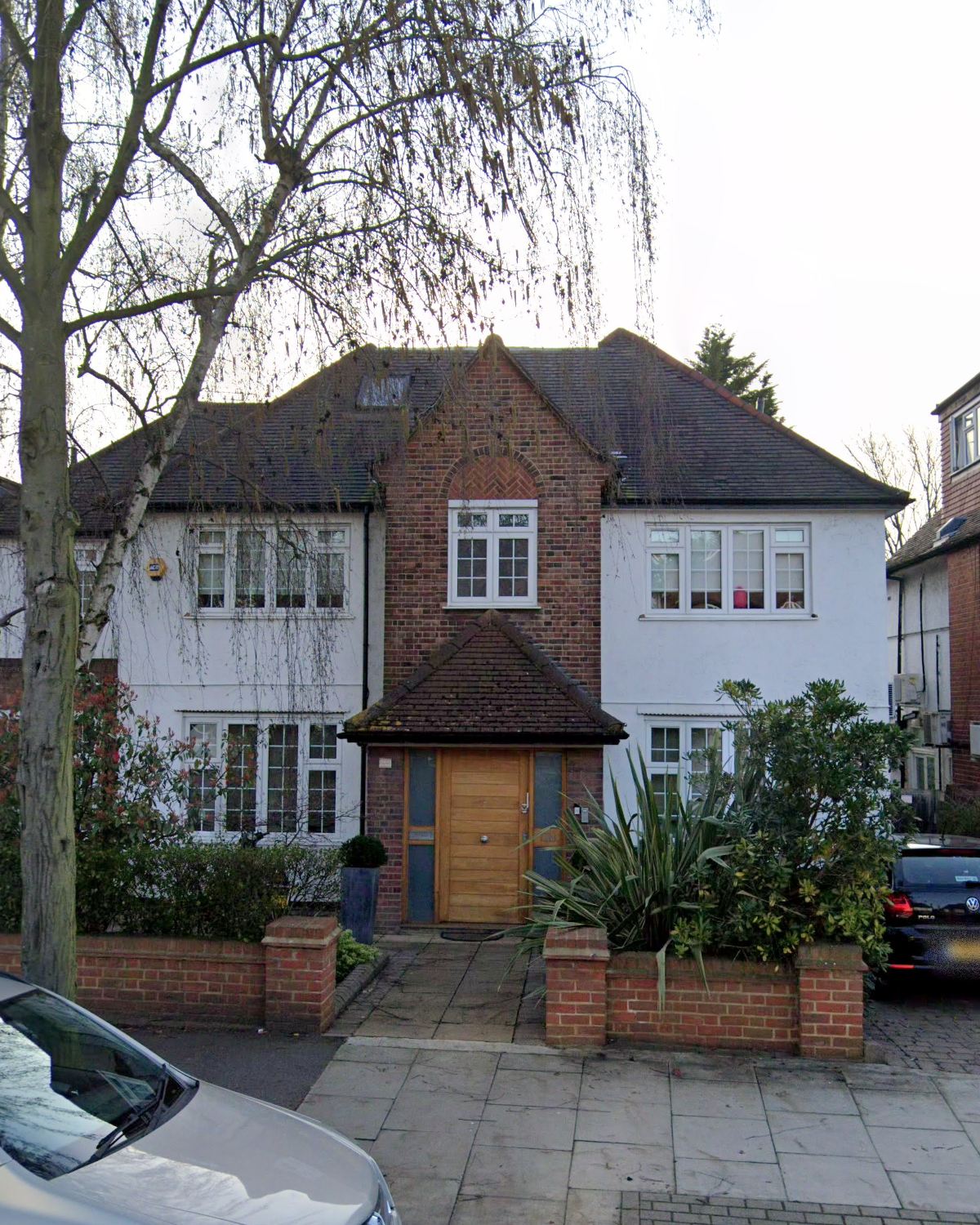 Portrait view of the façade with its brick gable, white render and oak door