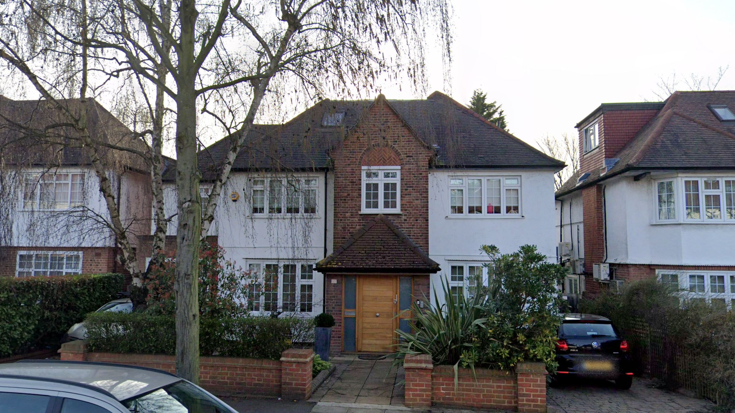 Front elevation of 103 Princes Park Avenue: white render, red-brick central gable and a solid oak front door